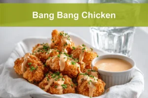 Bang Bang Chicken golden crispy pieces drizzled with sauce and fresh herbs on white cloth