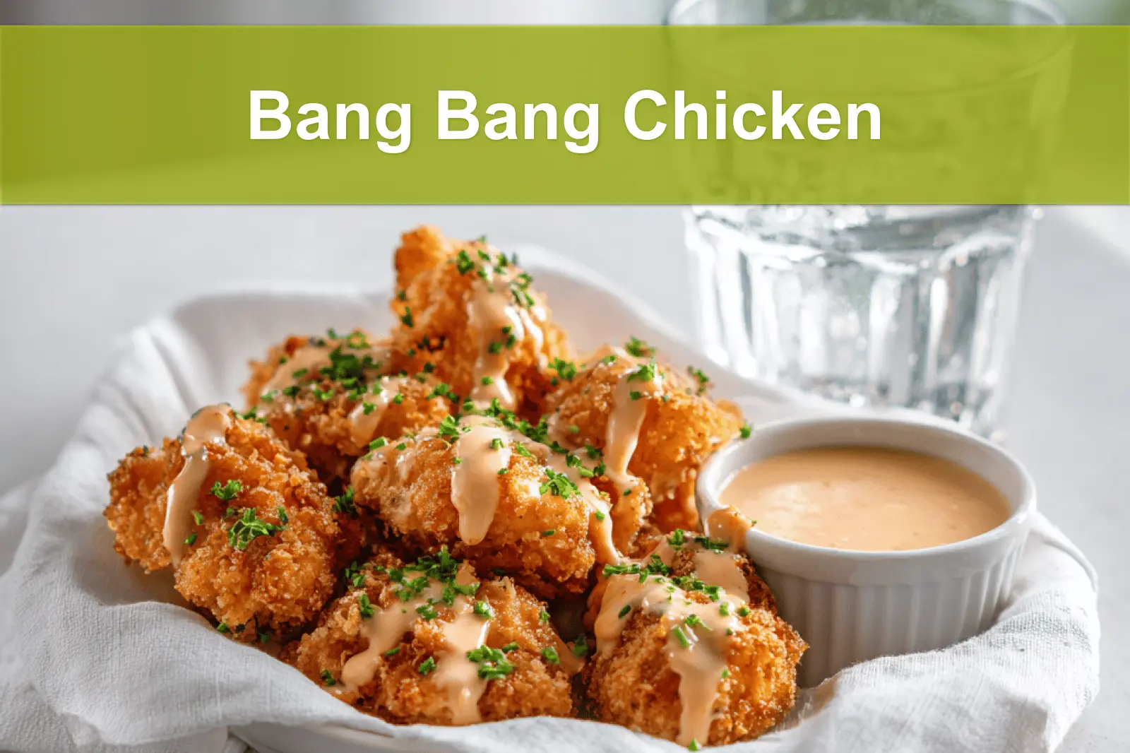 Bang Bang Chicken golden crispy pieces drizzled with sauce and fresh herbs on white cloth