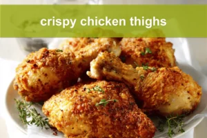 Crispy chicken thighs plated on white cloth with clear glass of water warm natural light