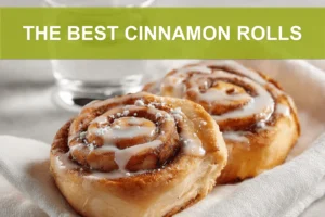 THE BEST CINNAMON ROLLS warm glazed pastries on white cloth with glass of water