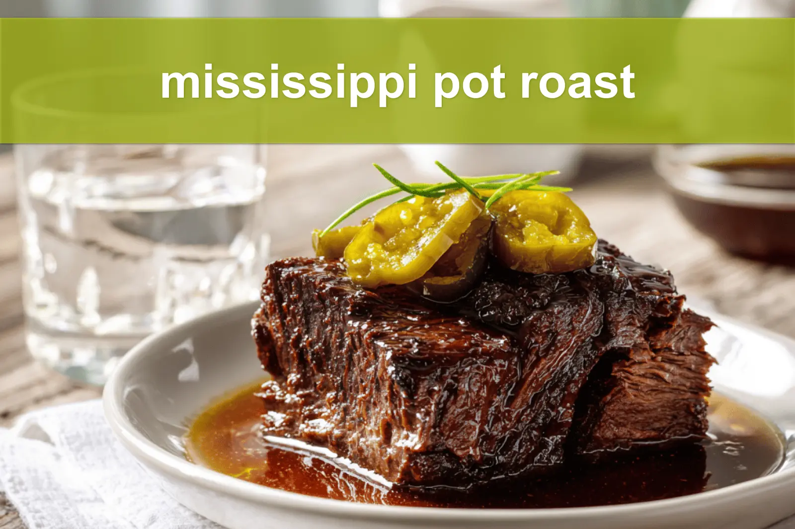 mississippi pot roast on white napkin with buttery glaze and clear glass of water