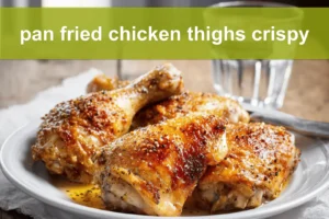 pan fried chicken thighs crispy golden skin on white cloth with simple glass of water